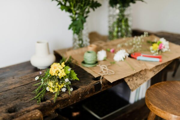 Fresh bouquet of flowers on table with floristry tools