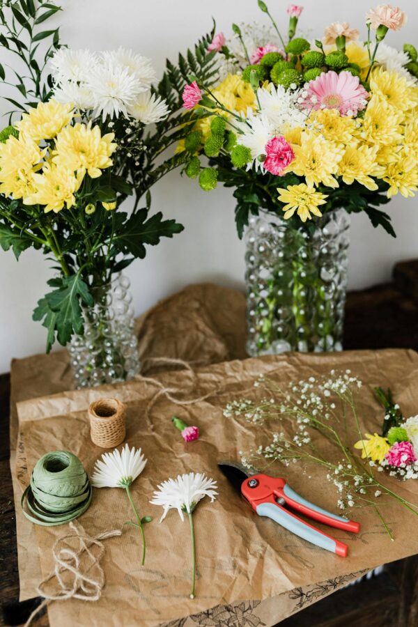 Pruner and twine rolls on table with flower bouquets